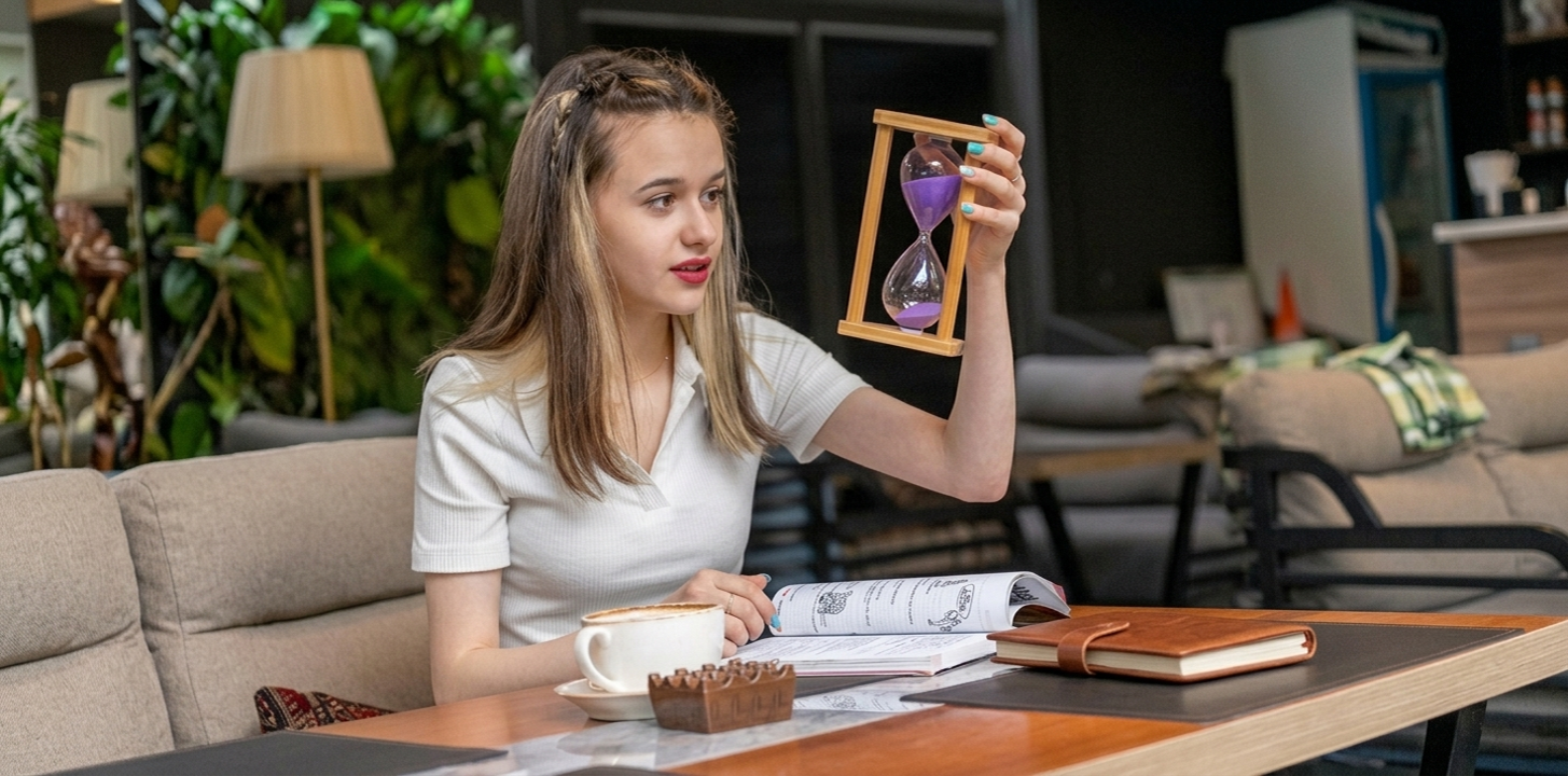 smiling lady holding hourglass